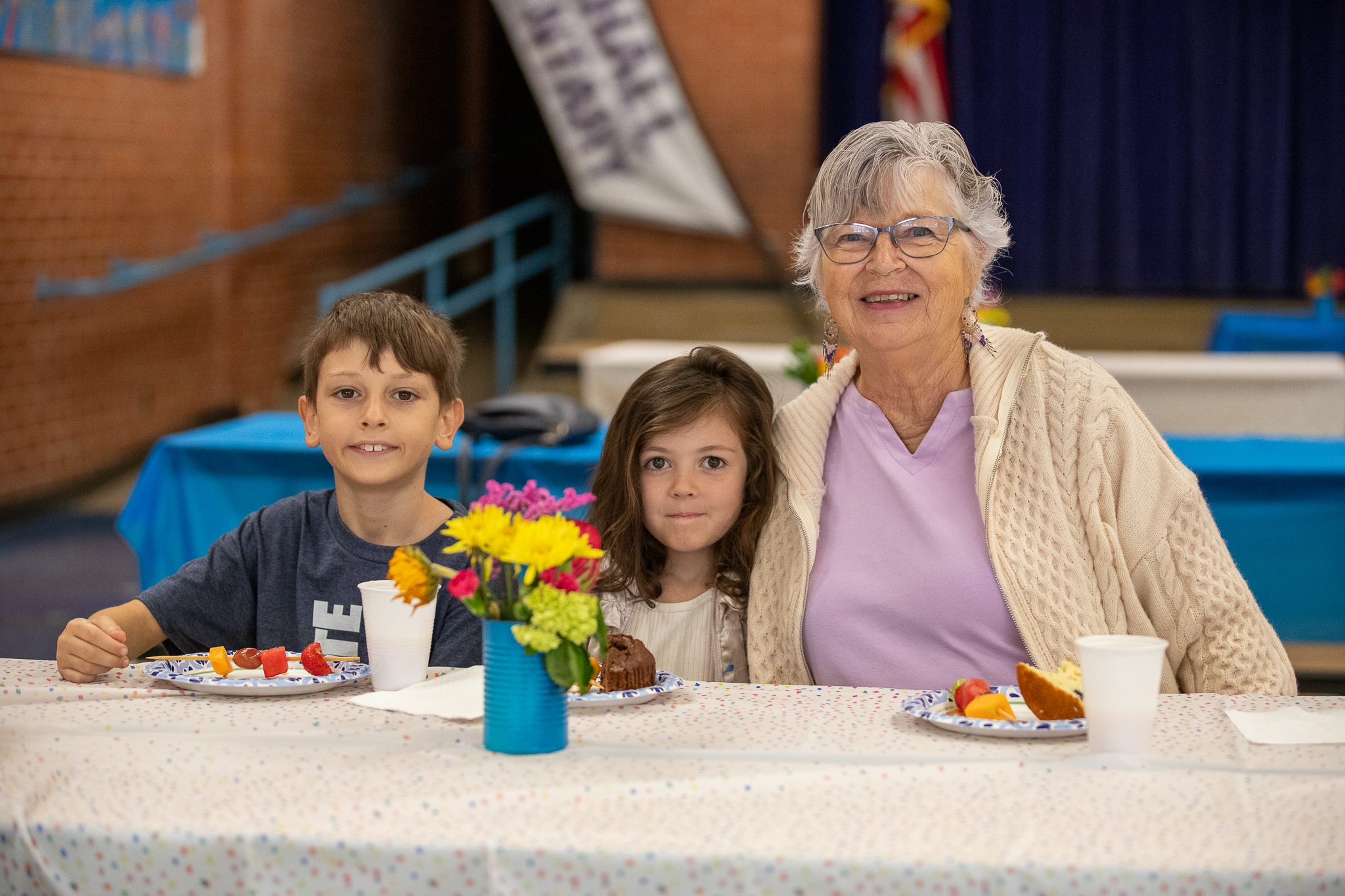 A grandma and her grandson and granddaughter enjoy breakfast together in the cafeteria