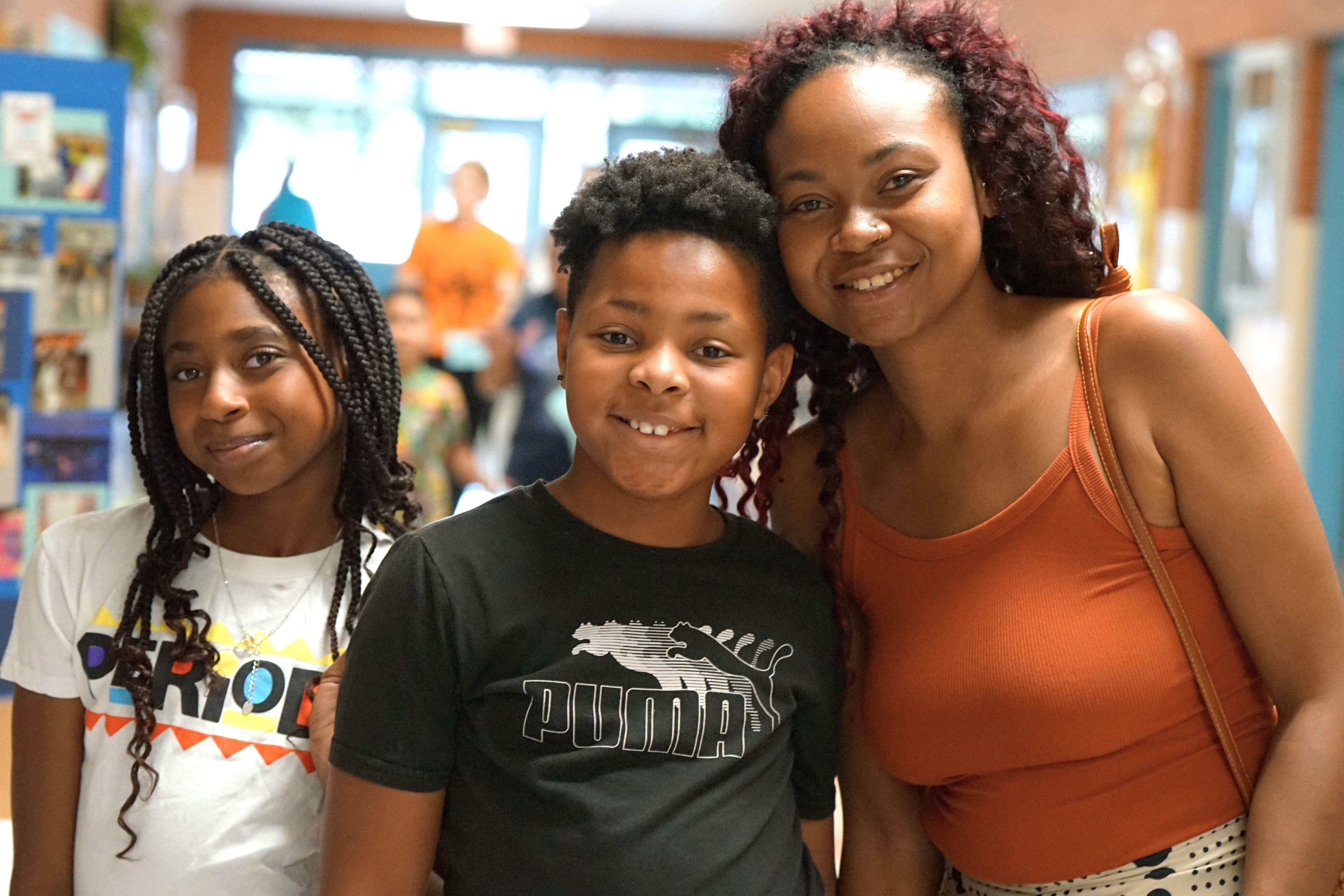 A mom and her son and daughter smile for a photo at the ice cream social