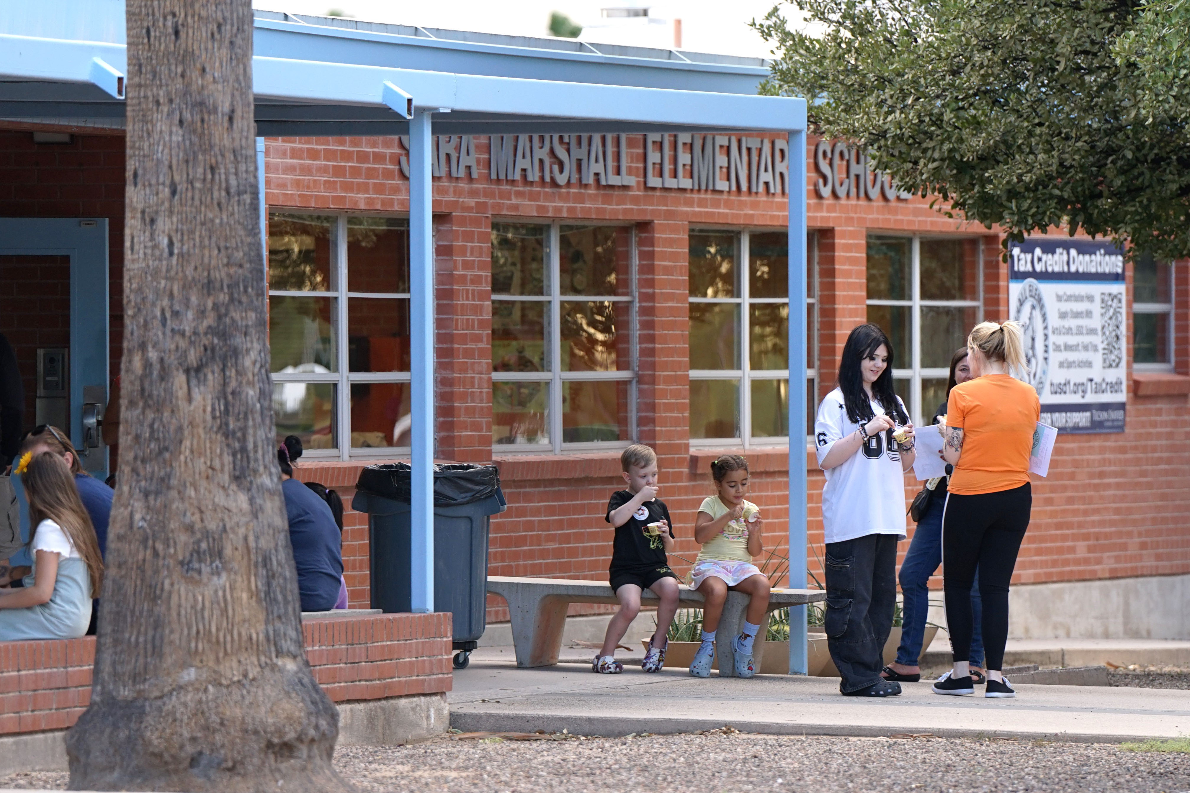 Families sit outside enjoying their ice cream treats