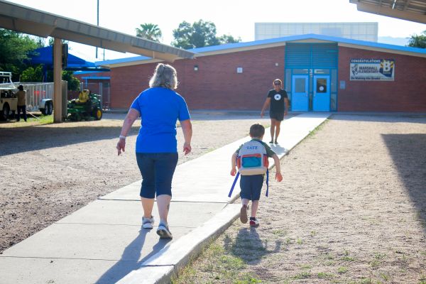 A woman and a boy walk into school