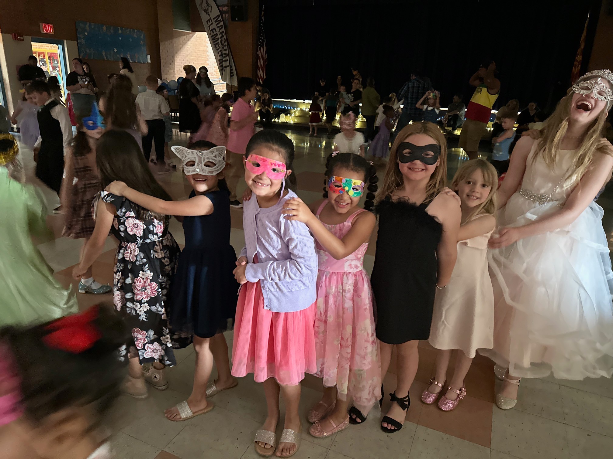 Students show off their masquerade masks during a school dance